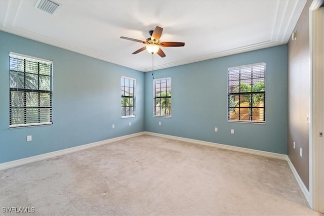 empty room featuring visible vents, ornamental molding, light carpet, ceiling fan, and baseboards