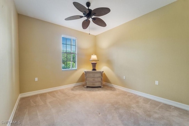 unfurnished room featuring light carpet, a ceiling fan, and baseboards