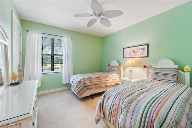 bedroom with light carpet, a ceiling fan, and baseboards