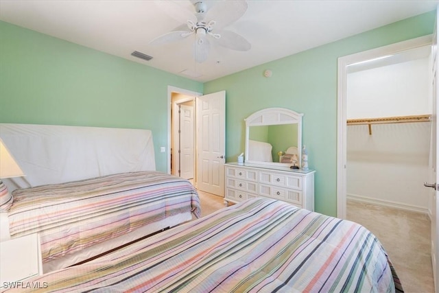 bedroom featuring ceiling fan, light colored carpet, visible vents, baseboards, and a closet