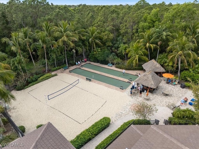 surrounding community featuring a view of trees and volleyball court