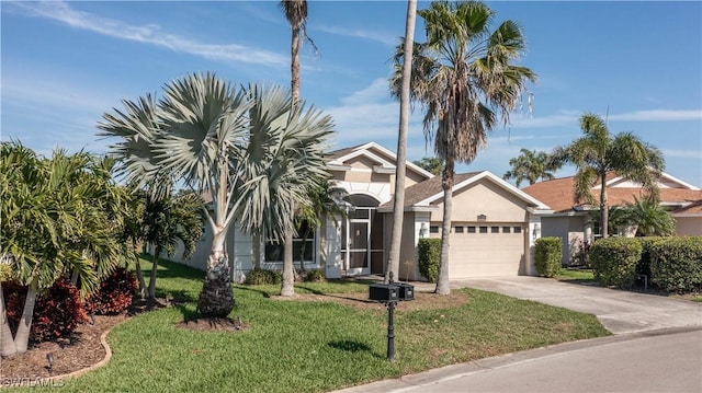 view of front of property featuring driveway, a front lawn, an attached garage, and stucco siding