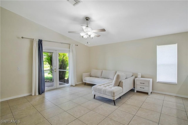 living area featuring lofted ceiling, light tile patterned floors, baseboards, and visible vents