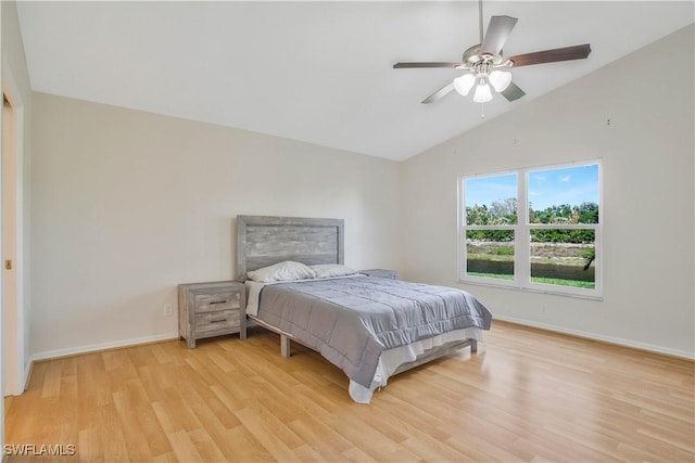 bedroom with vaulted ceiling, baseboards, and light wood-style floors