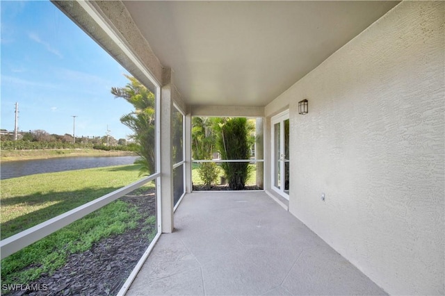 unfurnished sunroom featuring a water view