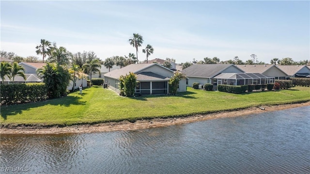 rear view of house with a lawn and a water view