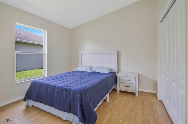 bedroom with a closet, baseboards, and wood finished floors