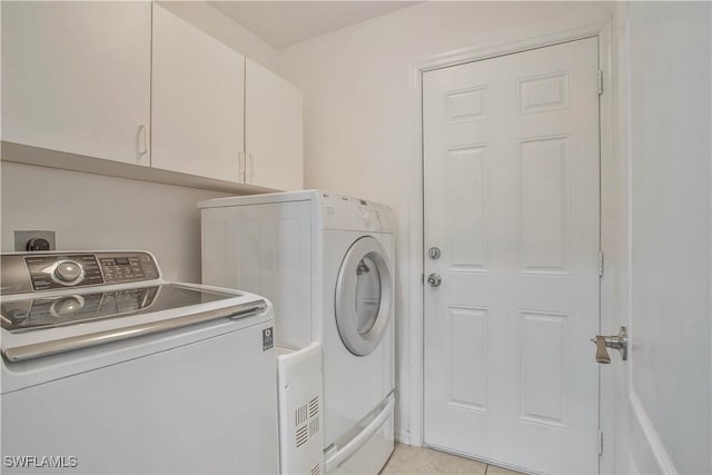 clothes washing area featuring washer and dryer and cabinet space