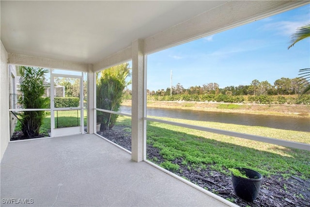 unfurnished sunroom featuring a water view