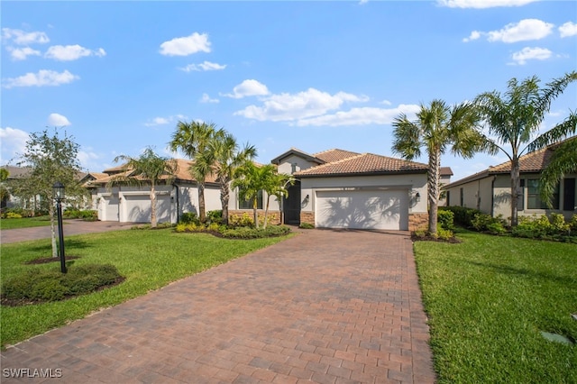 view of front of house with a garage, stone siding, decorative driveway, a front lawn, and stucco siding