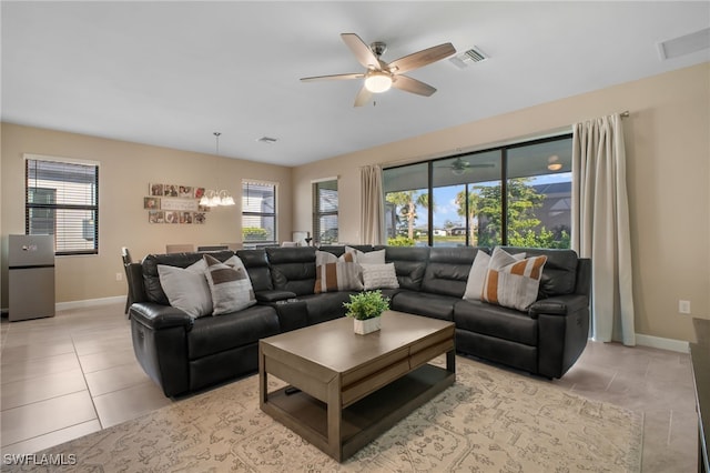 living room with light tile patterned floors, baseboards, visible vents, and a healthy amount of sunlight