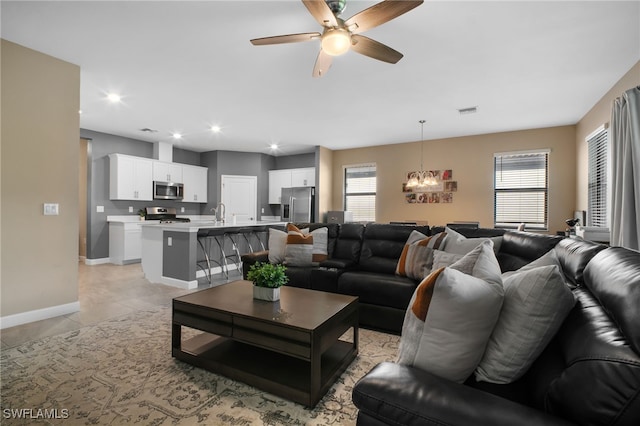 living room featuring recessed lighting, visible vents, light tile patterned flooring, baseboards, and ceiling fan with notable chandelier