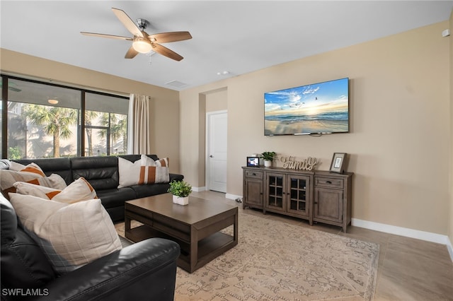 living area featuring ceiling fan, visible vents, and baseboards