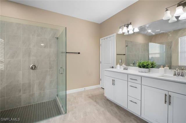 bathroom with a stall shower, a sink, baseboards, and double vanity