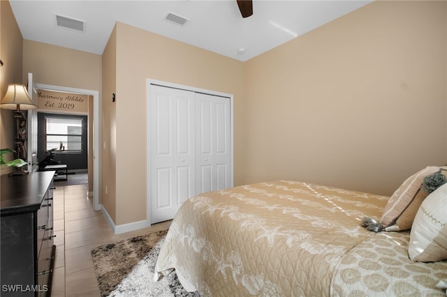 tiled bedroom featuring a ceiling fan, a closet, visible vents, and baseboards