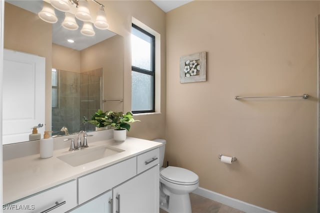 full bathroom featuring baseboards, a shower stall, toilet, and vanity