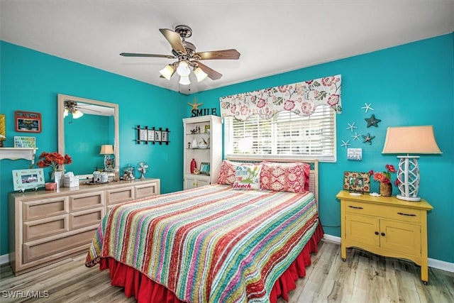 bedroom with light wood-style floors, baseboards, and a ceiling fan