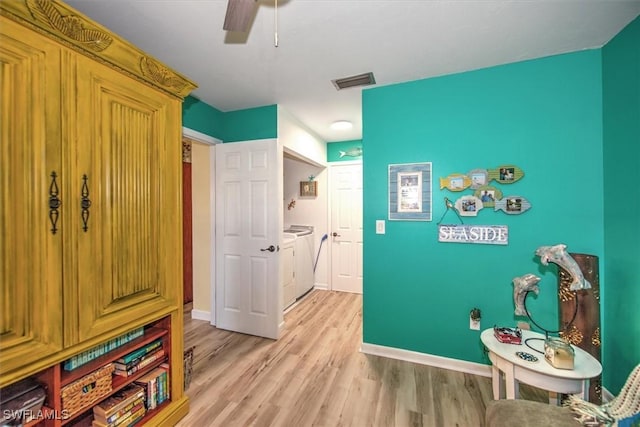 game room featuring visible vents, baseboards, a ceiling fan, light wood-style flooring, and washing machine and clothes dryer