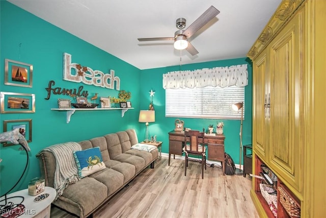 sitting room with baseboards, light wood-style flooring, and a ceiling fan