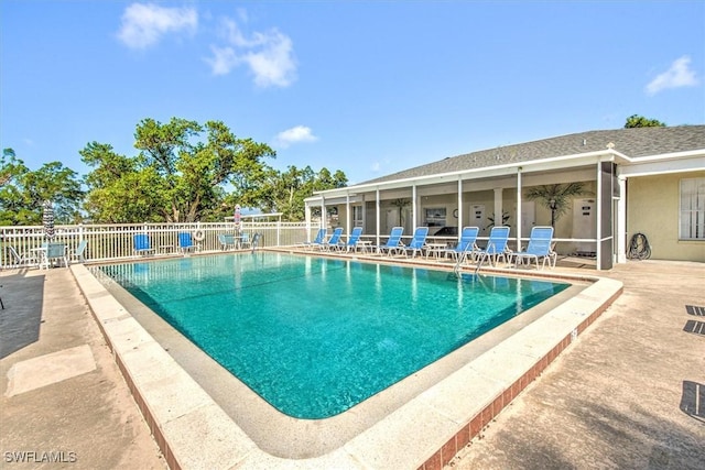 pool with a patio area and fence