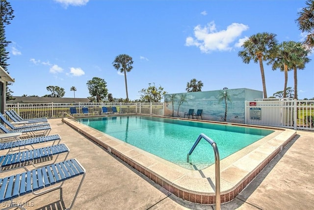 pool with a patio area and fence