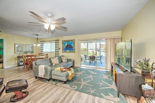 living room featuring ceiling fan, light wood-type flooring, and baseboards