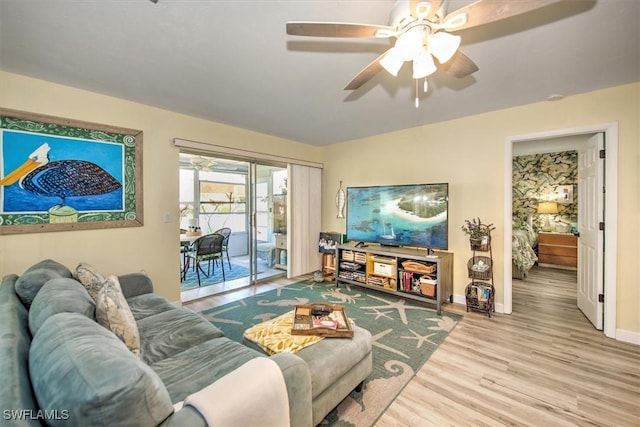 living area with light wood-style flooring, baseboards, and ceiling fan