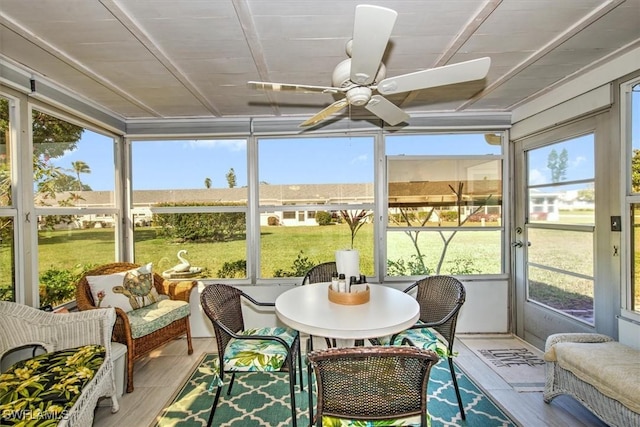 sunroom / solarium featuring plenty of natural light and a ceiling fan