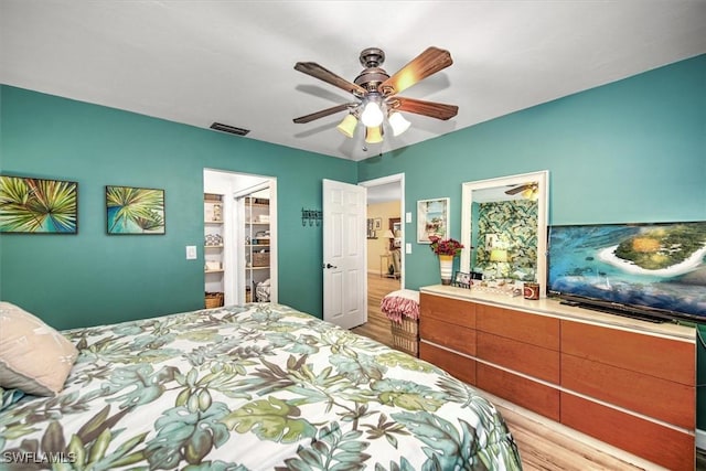 bedroom featuring visible vents, ceiling fan, and light wood-style flooring