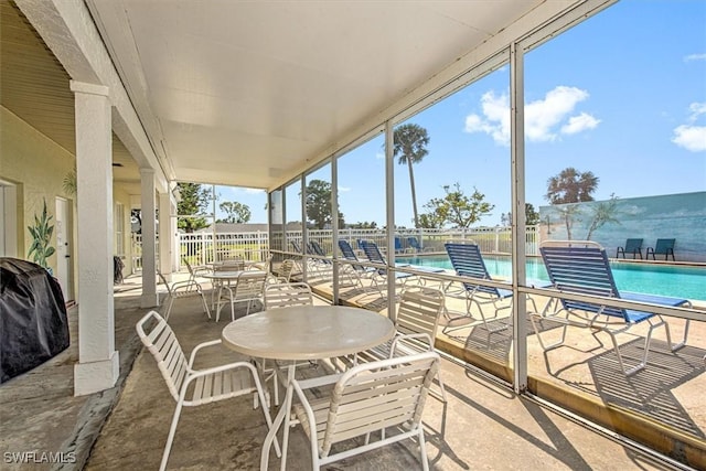 view of patio / terrace with outdoor dining space, a water view, fence, and a community pool