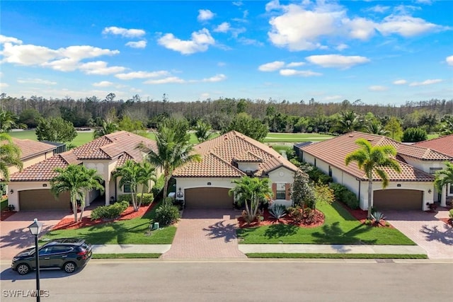 view of front of property featuring a garage, decorative driveway, and a front yard