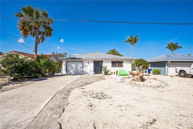 single story home featuring concrete driveway and an attached garage