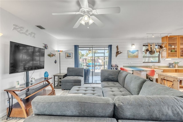 living area featuring rail lighting, visible vents, and ceiling fan