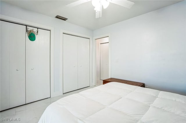 16221 Buccaneer St, Bokeelia, FL 33922 - bedroom featuring marble finish floor, visible vents, a ceiling fan, and multiple closets