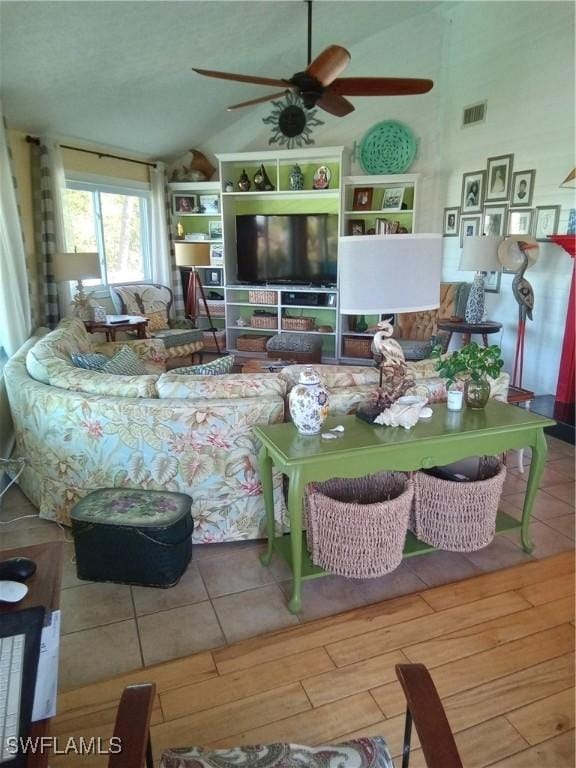 living area with lofted ceiling, visible vents, ceiling fan, and wood finished floors