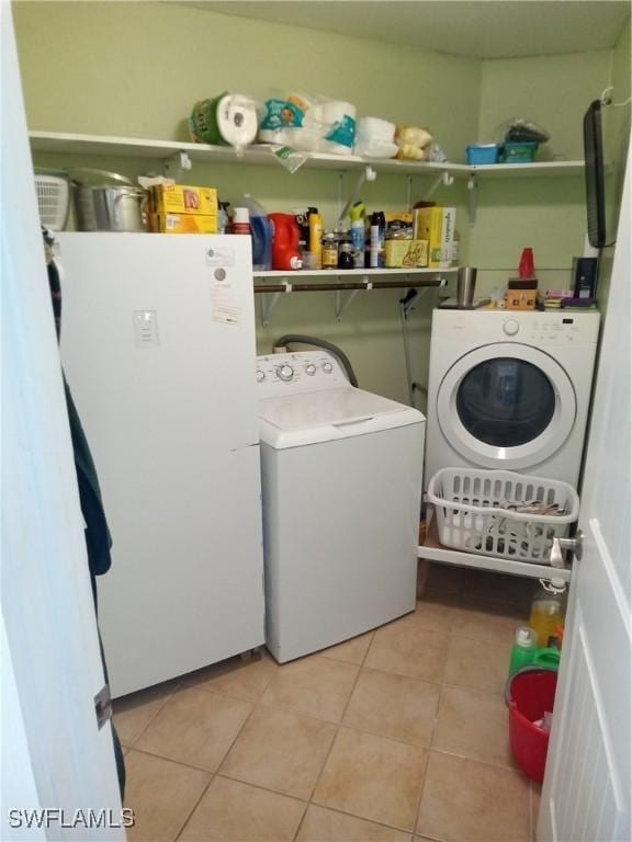 washroom featuring light tile patterned floors, laundry area, and washer and dryer