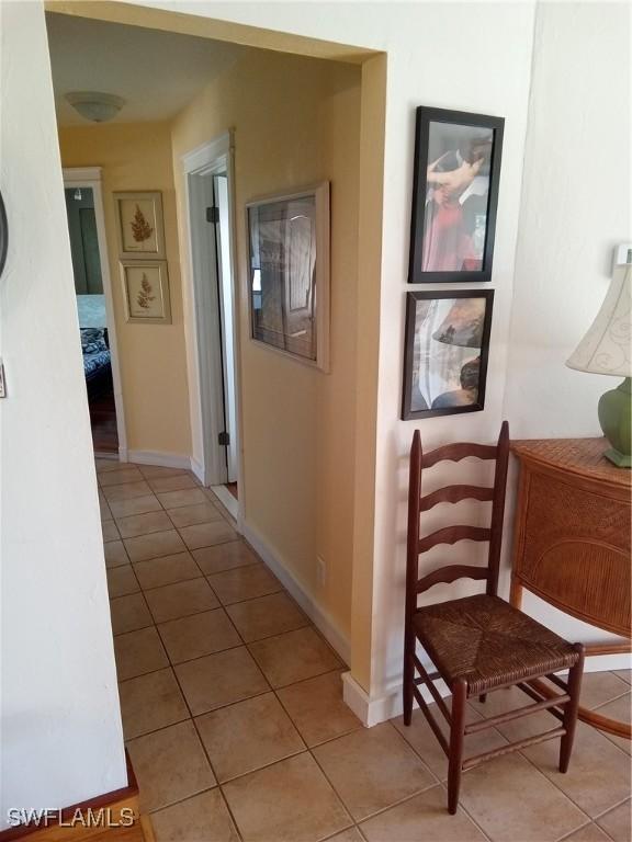 hallway with light tile patterned floors and baseboards