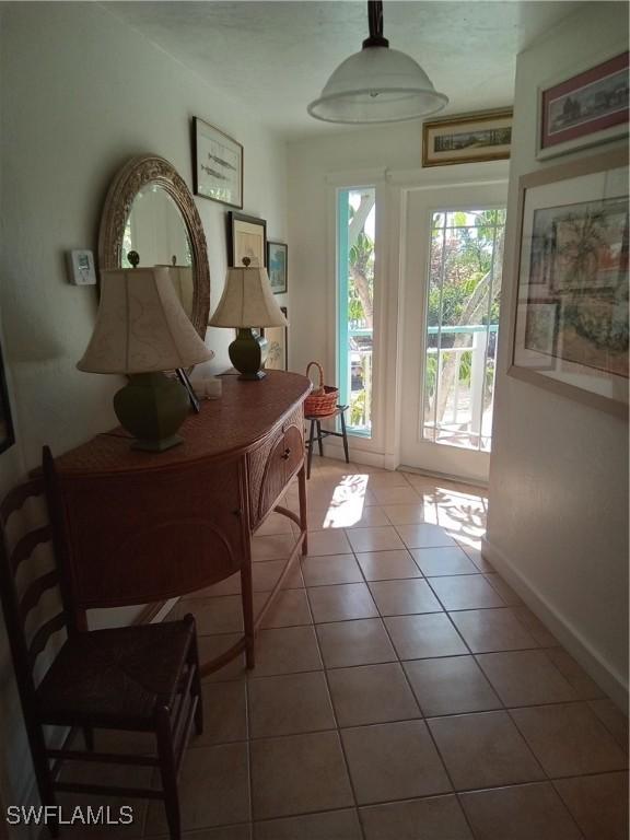 doorway with tile patterned flooring and baseboards