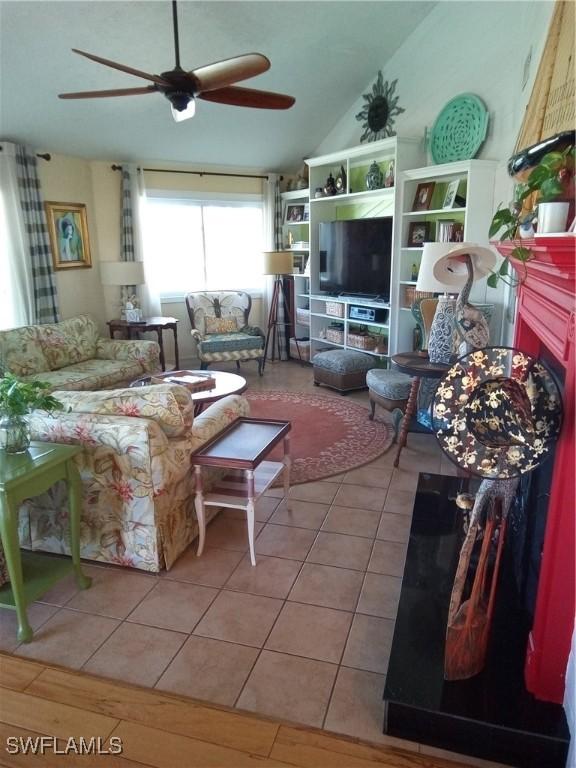 tiled living room with lofted ceiling and ceiling fan