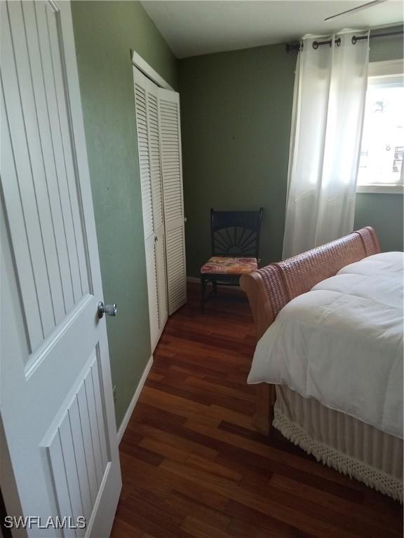 bedroom featuring a closet, baseboards, and wood finished floors