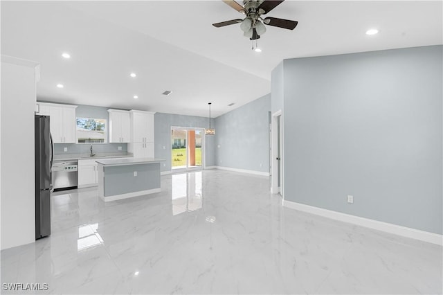 kitchen with open floor plan, dishwasher, light countertops, freestanding refrigerator, and white cabinets