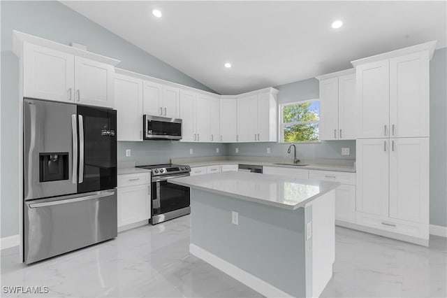 kitchen featuring a center island, appliances with stainless steel finishes, marble finish floor, white cabinetry, and a sink