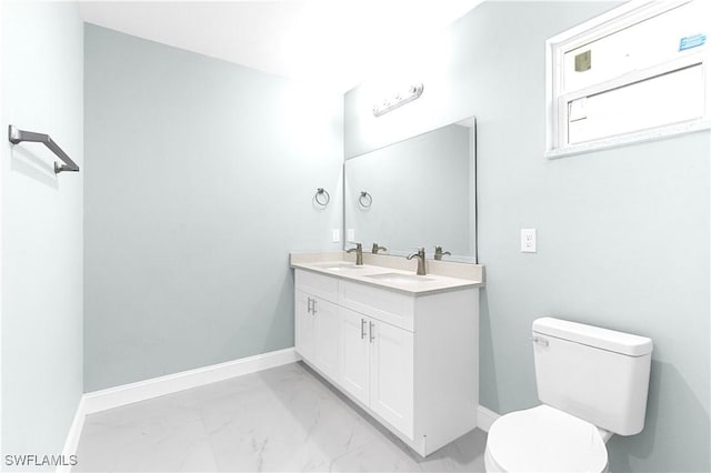 bathroom with a sink, baseboards, toilet, and marble finish floor