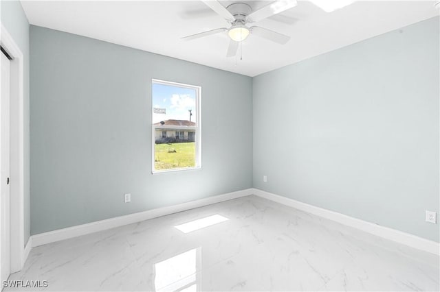 empty room with baseboards, marble finish floor, and a ceiling fan