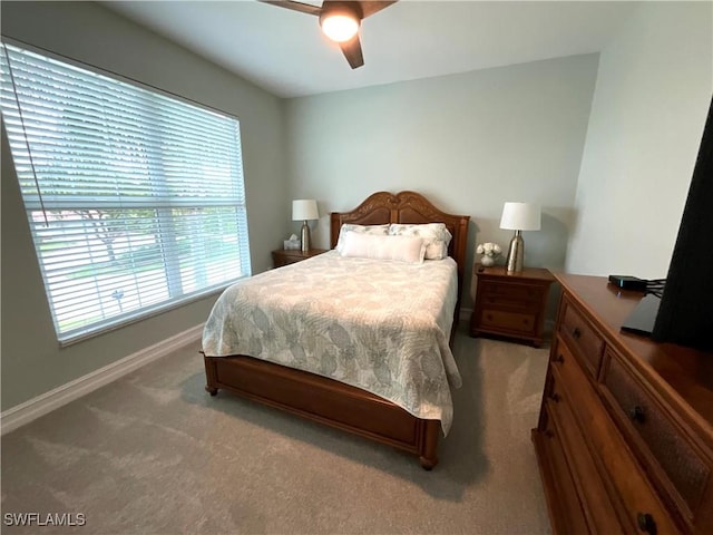 carpeted bedroom with ceiling fan and baseboards