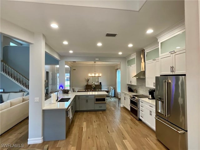 kitchen with glass insert cabinets, appliances with stainless steel finishes, light countertops, and white cabinets