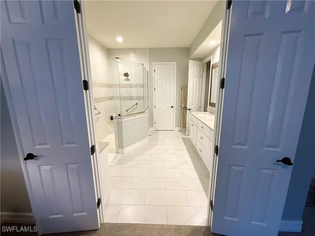 bathroom with a stall shower, recessed lighting, baseboards, and vanity