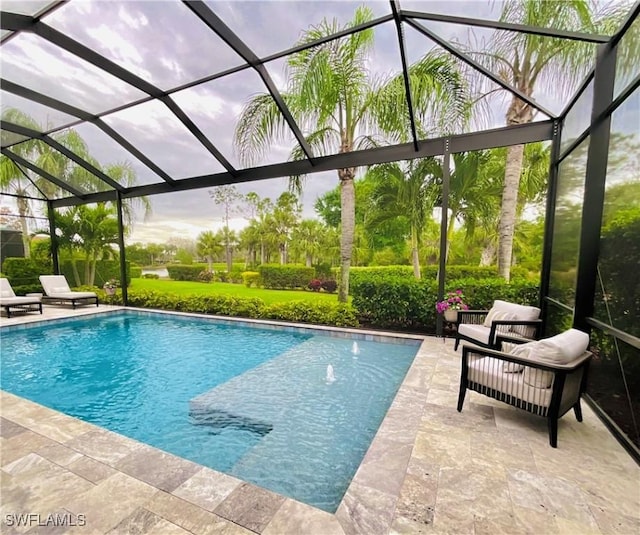 outdoor pool featuring glass enclosure and a patio