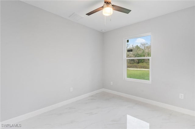 spare room with ceiling fan, marble finish floor, visible vents, and baseboards