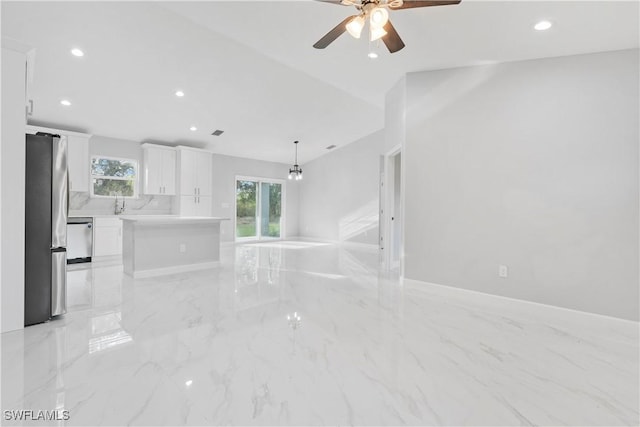 unfurnished living room with a ceiling fan, recessed lighting, and marble finish floor